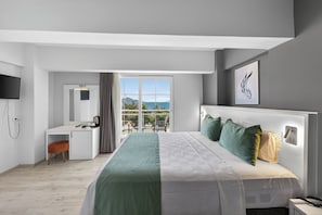 Ein modernes Hotelzimmer mit Bett, Schreibtisch und Balkon mit Blick.