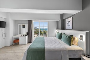 Una habitación de hotel moderna con cama, escritorio y balcón con vistas.