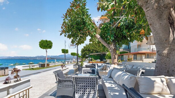 A seaside patio with wicker furniture, a white sofa, and a view of the sea. - Mia Casa Hotel (Fethiye)
