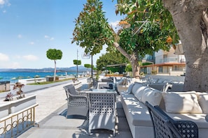 A seaside patio with wicker furniture, a white sofa, and a view of the sea. - Mia Casa Hotel (Fethiye)