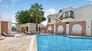 A swimming pool with lounge chairs and a palm tree. - Mia Casa Hotel (Fethiye)