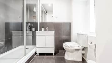 Standaard appartement, balkon | Badkamer | Een bad/douchecombinatie, een haardroger, handdoeken, zeep