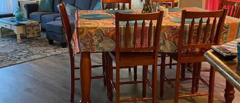 Un coin repas avec une table et des chaises en bois, un canapé et une lampe.