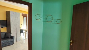 Ein Zimmer mit einer grünen Wand, einer Holztür und drei sechseckigen Wanddekorationen.