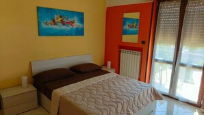Ein Schlafzimmer mit einem Bett, Nachttischen und zwei Bildern an der Wand.