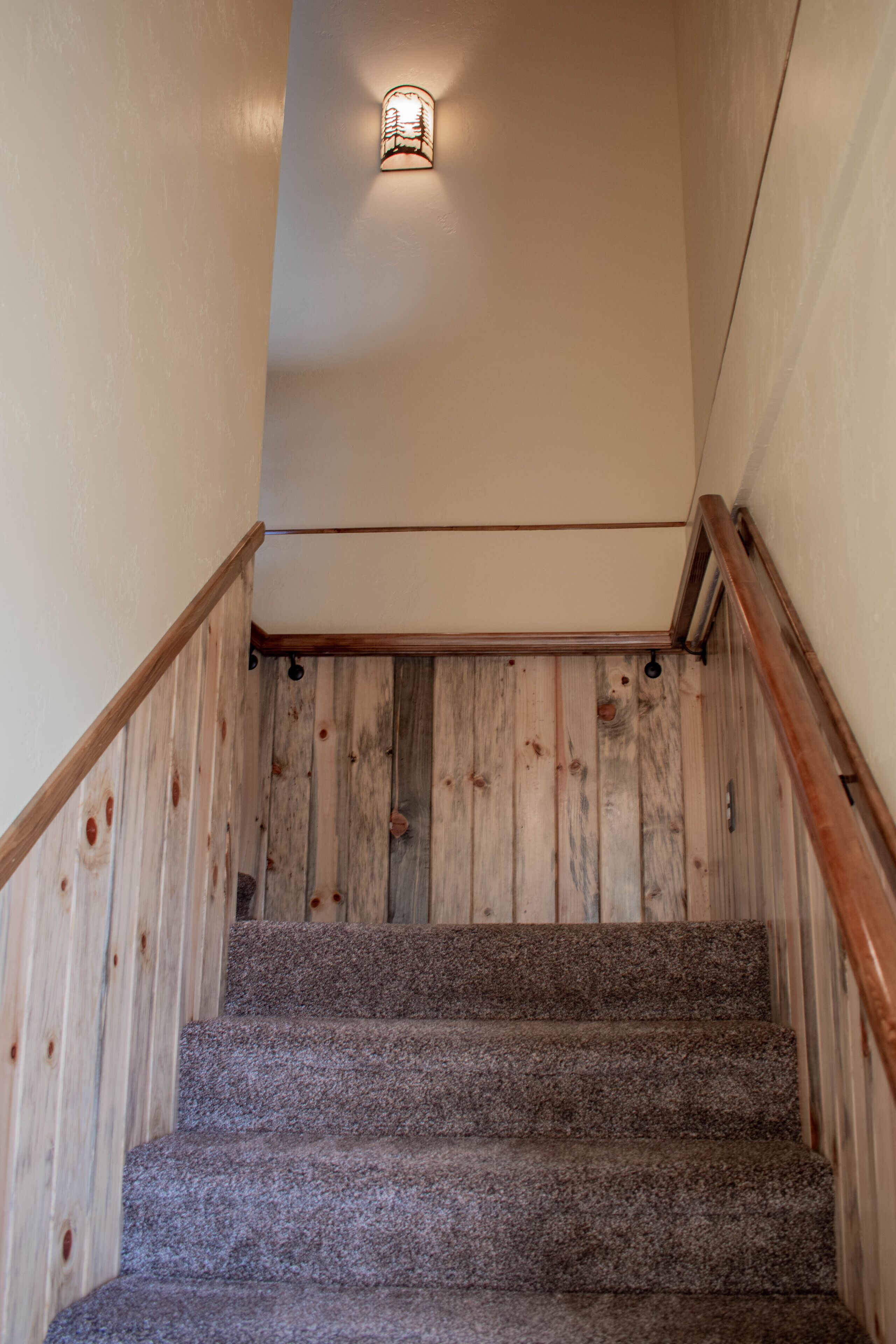 Una escalera con paneles de madera y peldaños alfombrados.