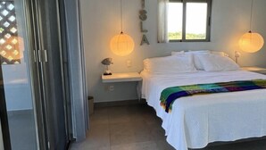 Ein Schlafzimmer mit Bett, Deckenventilator, Fenster und Nachttisch.