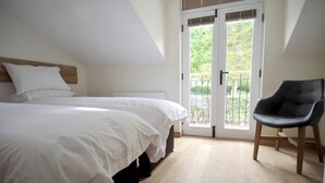 Une chambre à coucher comprenant un lit, une chaise, un radiateur et une porte donnant sur un balcon.