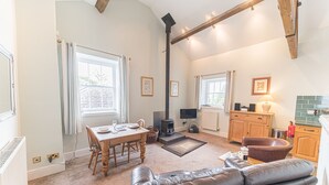 Een gezellige woonkamer met een open haard, een eethoek en een keuken.