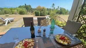 Ein Esstisch mit zwei Teller Essen, einer Weinflasche und einem Wasserglas.