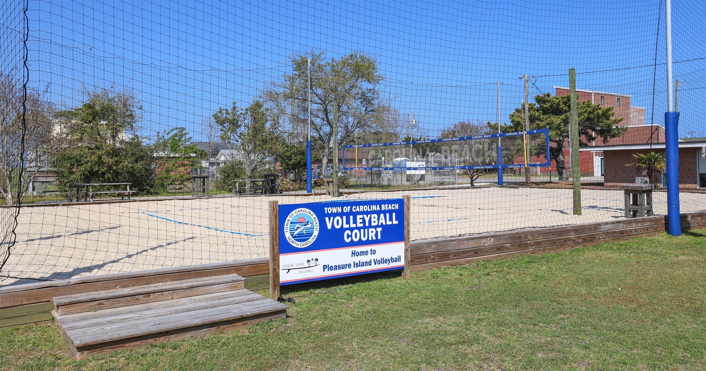 A volleyball court with a sign indicating it's part of the Town of Carolina Beach.