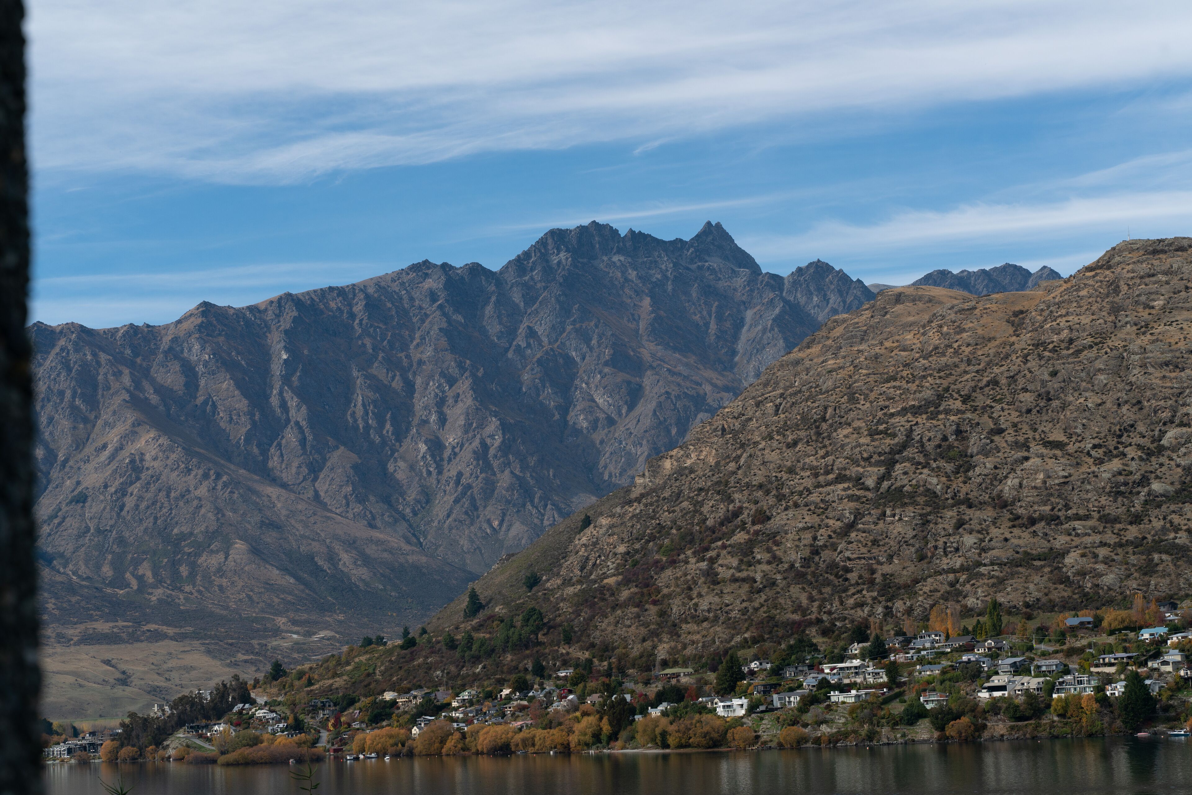 A mountainous landscape with a lake and a small settlement.