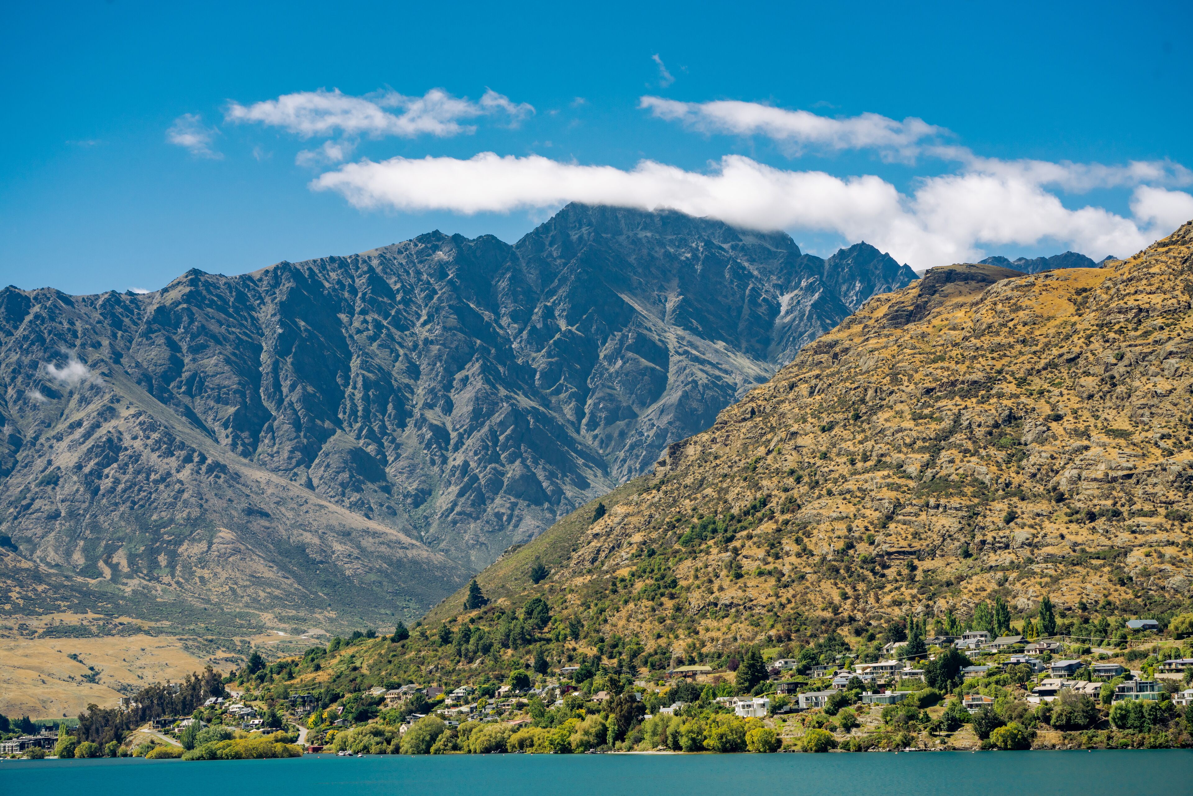 A mountainous landscape with a lake and a small settlement.