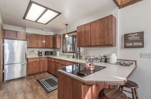 Eine moderne Küche mit Holzausbau, Edelstahlgeräten und einer Bar.