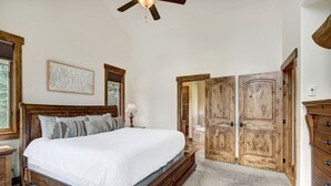 Ein Schlafzimmer mit einem großen Bett, einem Holzschrank und einem Deckenventilator.