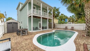 A two-story house with a pool, a covered patio, and a fenced backyard. - Panama City Beach House with Heated Private Pool, Gulf Views, & Steps to Beach! (Panama City Beach)