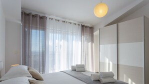 A modern hotel room with a large bed, a bedside table with a lamp, a wardrobe, and sheer curtains. - Villa Melki SAVE 20 percent on Split-villas com (Klis)
