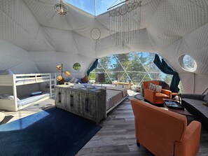Un intérieur chaleureux avec un lit superposé, une armoire en bois, un canapé et une table basse.