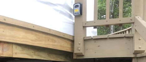 En byggarbetsplats med en träkonstruktion, en svart container och en stor grå panel.