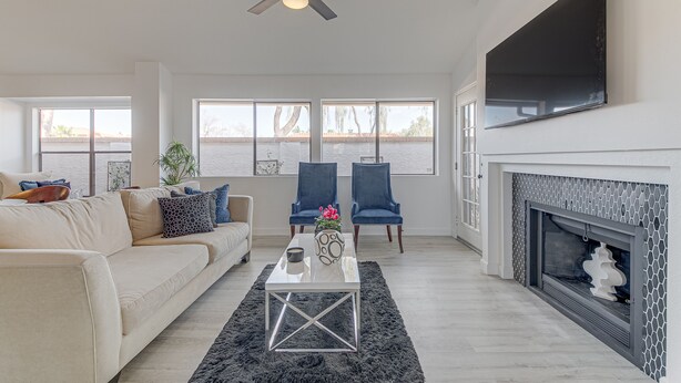 A living room with a sofa, two chairs, a coffee table, a fireplace, and a TV mounted on the wall. - Scottsdale Resort Getaway!! Newly Renovated!! (Scottsdale)