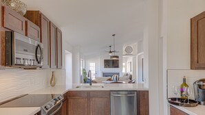 A modern kitchen with wooden cabinets, stainless steel appliances, and a central island. - Scottsdale Resort Getaway!! Newly Renovated!! (Scottsdale)