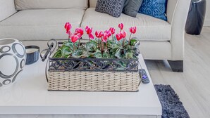 A modern living room with a white sofa, a coffee table with a plant, and a remote control. - Scottsdale Resort Getaway!! Newly Renovated!! (Scottsdale)