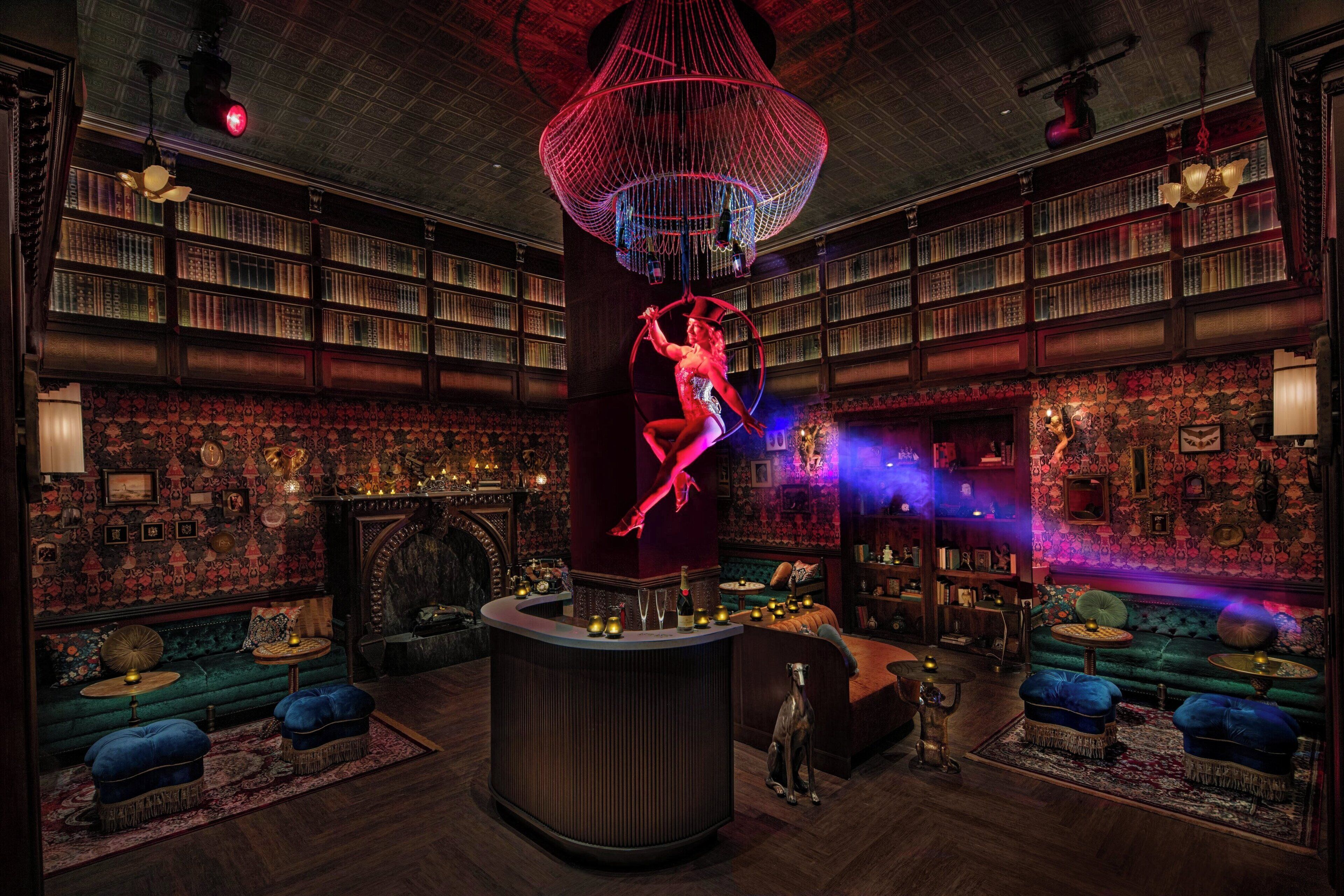 A library with bookshelves, a central bar area, and a dog.