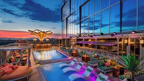 A rooftop pool area with lounge chairs and a large, illuminated structure. - AC Hotel Downtown Los Angeles, a Marriott Hotel (Los Angeles)