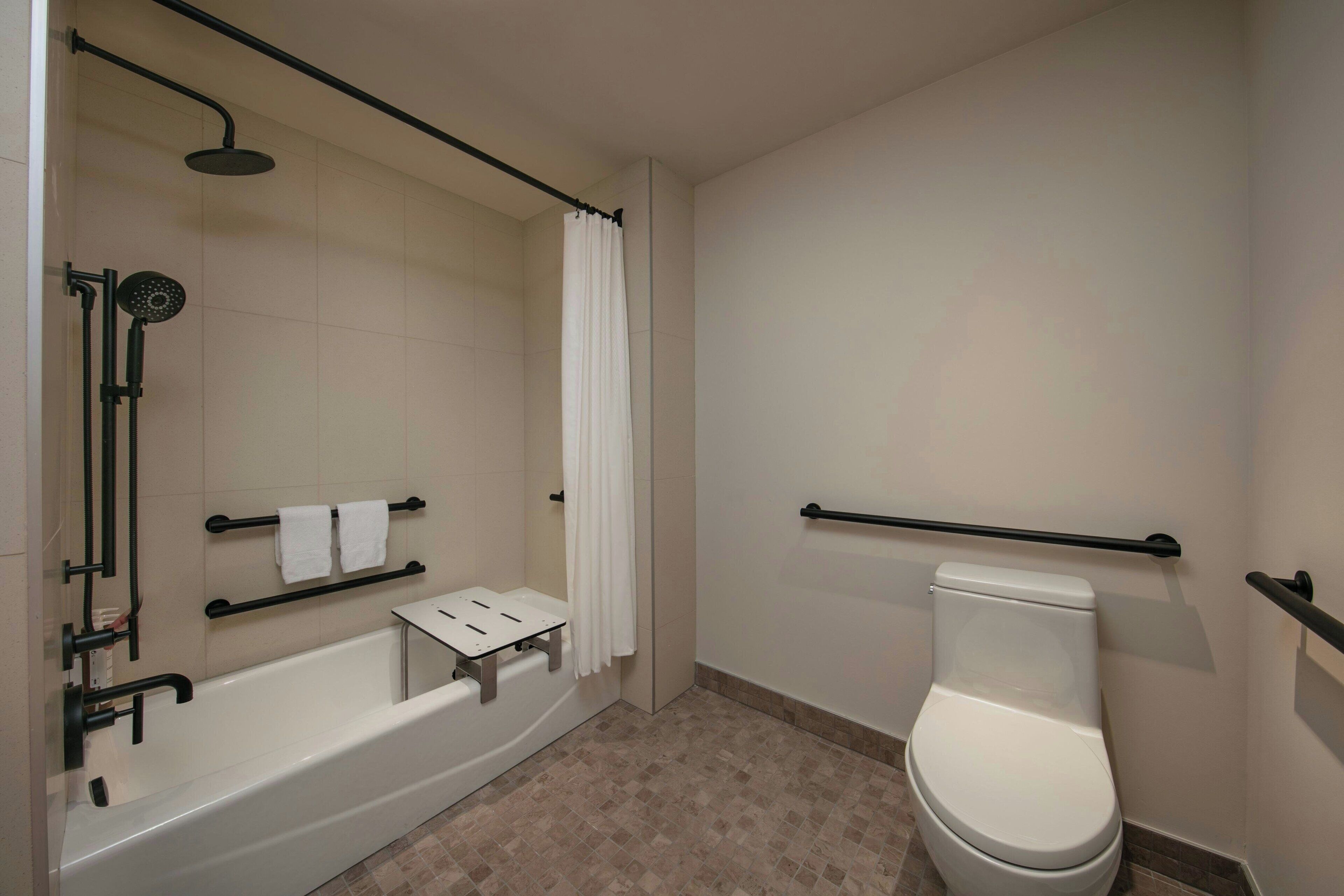 Ein modernes Badezimmer mit Badewanne, Dusche und Toilette.