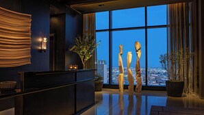 A modern lobby with a reception desk, large windows offering a city view, and abstract sculptures. - AC Hotel Downtown Los Angeles, a Marriott Hotel (Los Angeles)