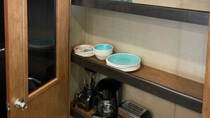 Eine Küche mit Holzausstattung, einer Kaffeemaschine und einem Toaster auf der Arbeitsfläche.