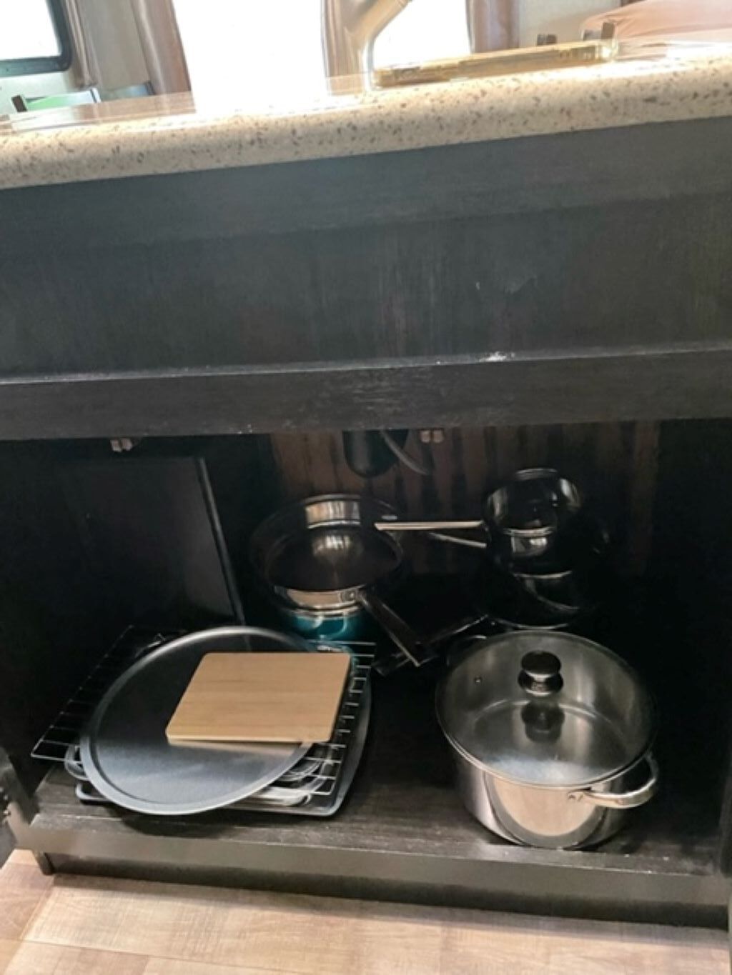 A kitchen with a stove, a frying pan, and a pot.