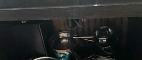 Una cocina con estufa, sartén y olla.