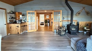 Interior espaçoso de cabana com cozinha, sala de jantar e uma sala de estar aconchegante.