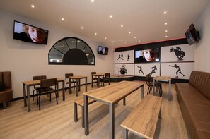 A modern interior with multiple seating areas, including tables and chairs, and a large curved window.