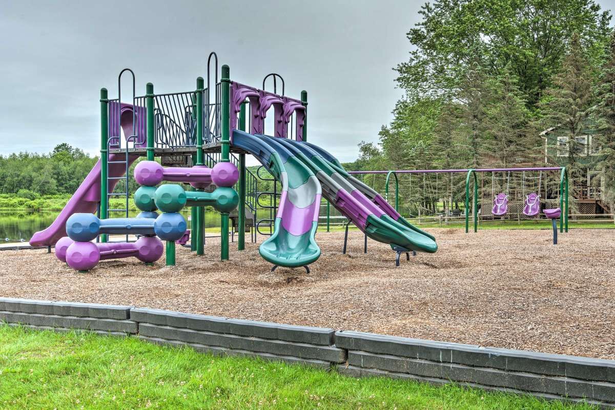 A playground with a slide, climbing structures, and swings.