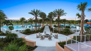 A resort with multiple swimming pools, a central fire pit area with seating, and palm trees. - Two Villas Two Resorts Two Blocks Apart Sleeps 41 (Kissimmee)