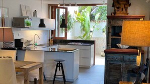 Een moderne keuken met een centraal eiland, een eethoek met een houten tafel en stoelen, en een traditioneel decoratiemakje.