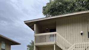 A two-story building with a balcony and a staircase leading to the entrance. - DAPHNE SCENIC BAY VIEW CONDO (Daphne)