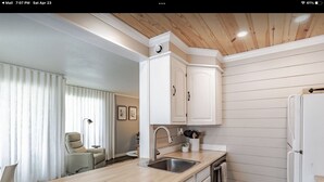 A modern kitchen with white cabinetry, a wooden countertop, and a stainless steel sink. - DAPHNE SCENIC BAY VIEW CONDO (Daphne)