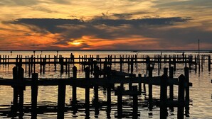 A pier extending into calm water with a sunset in the background. - DAPHNE SCENIC BAY VIEW CONDO (Daphne)