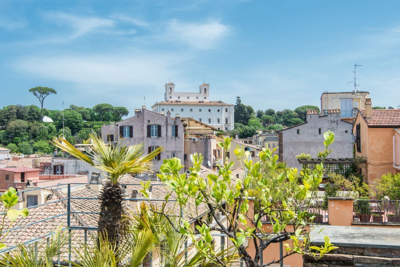 A residential area with a prominent white building with two towers, surrounded by other buildings and greenery.