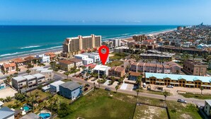 An aerial view of a coastal town with a hotel marked by a red pin. - Padre Parade • Private Heated Pool • 90-Second Walk to Beach (South Padre Island)