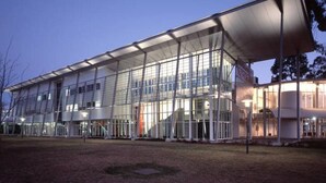 Un bâtiment moderne doté d’une façade en verre, d’une entrée abritée et d’un toit plat.