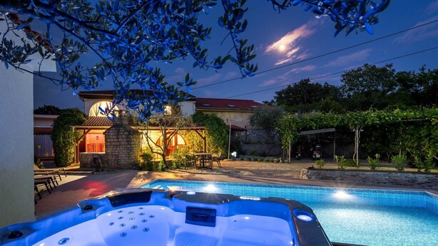 A backyard with a swimming pool, hot tub, and outdoor seating area. - Holiday House Stone Lady (Rasopasno)