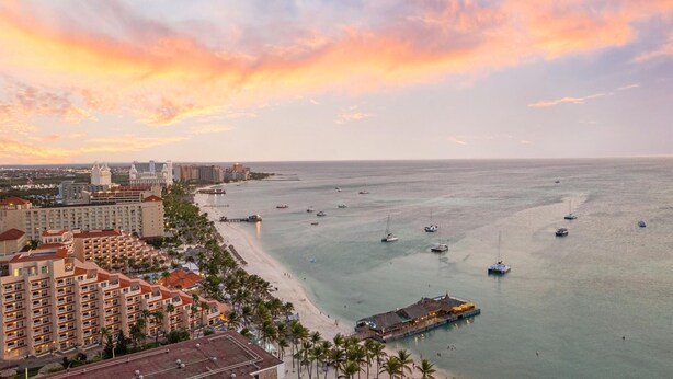 A coastal cityscape with a beachfront hotel, a pier, and boats in the water. - NEW 2BR Condo in  of Palm Beach! Walk 2 Beach! (Palm Beach)