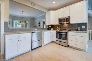 Enjoy cooking in this well-equipped kitchen with a large island, sink, microwave, and stovetop oven.