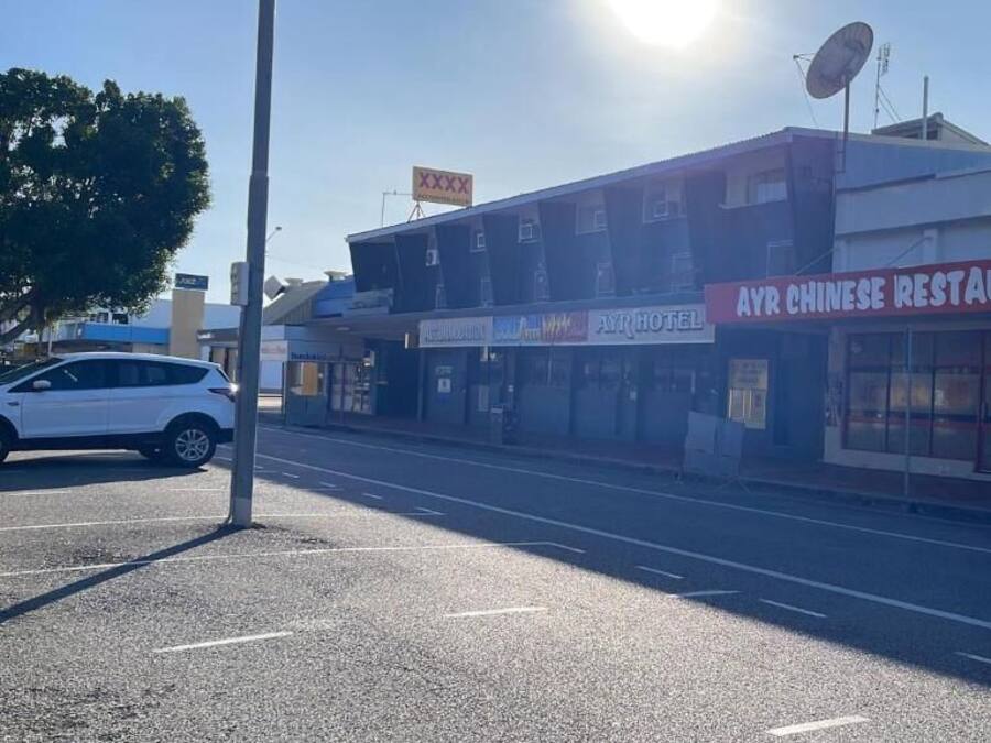 Straatbeeld met een gebouw waarop borden staan voor 'AYR CHINESE RESTAURANT' en 'AYR HOTEL'.