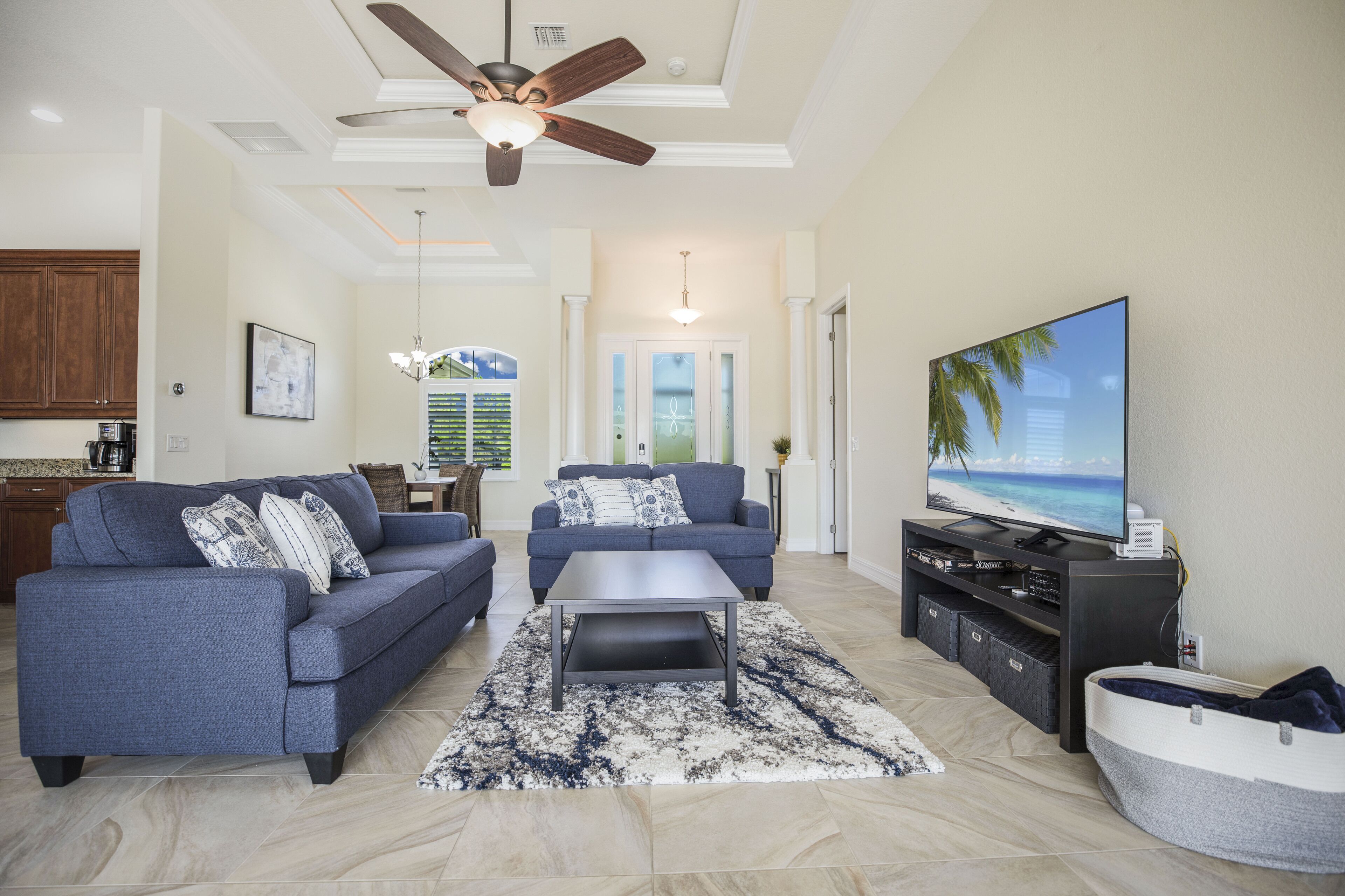 A living room with two sofas, a coffee table, a TV, and a ceiling fan.