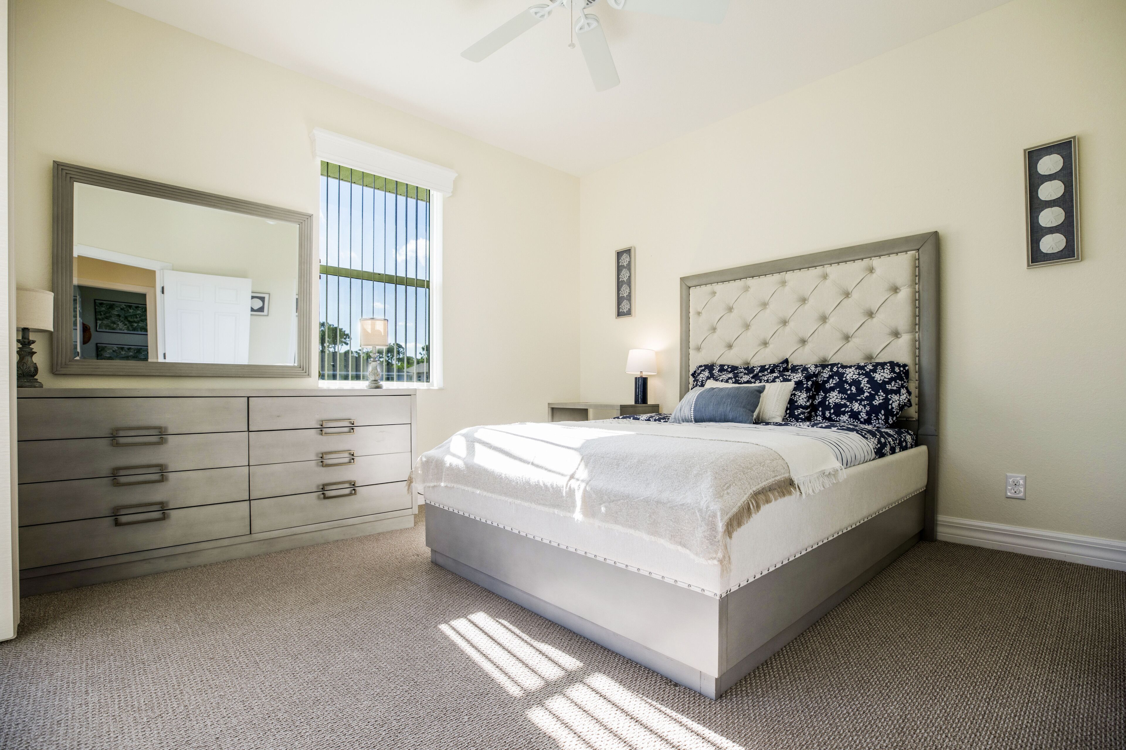 A bedroom with a bed, dresser, and window.